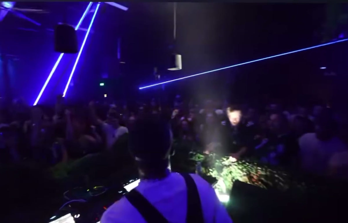 Load video: Warehouse event with a lot of happy people jumping around with lasers flying everywhere